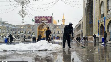 خدمت‌رسانی خادمان حرم مطهر رضوی به زائران در روز برفی مشهد + تصویر