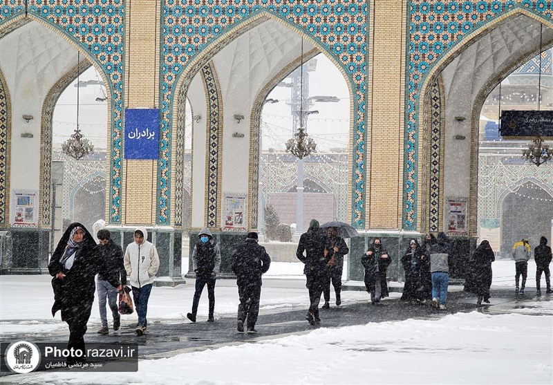 خدمت‌رسانی خادمان حرم مطهر رضوی به زائران در روز برفی مشهد + تصویر