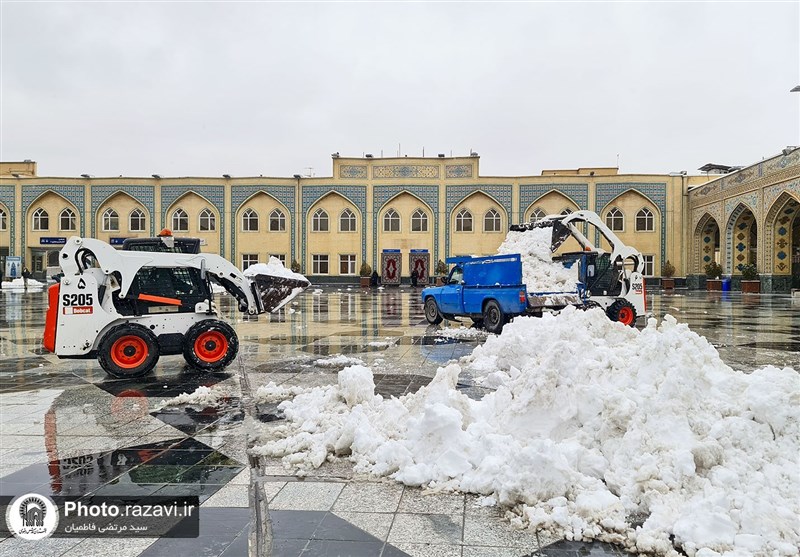 خدمت‌رسانی خادمان حرم مطهر رضوی به زائران در روز برفی مشهد + تصویر